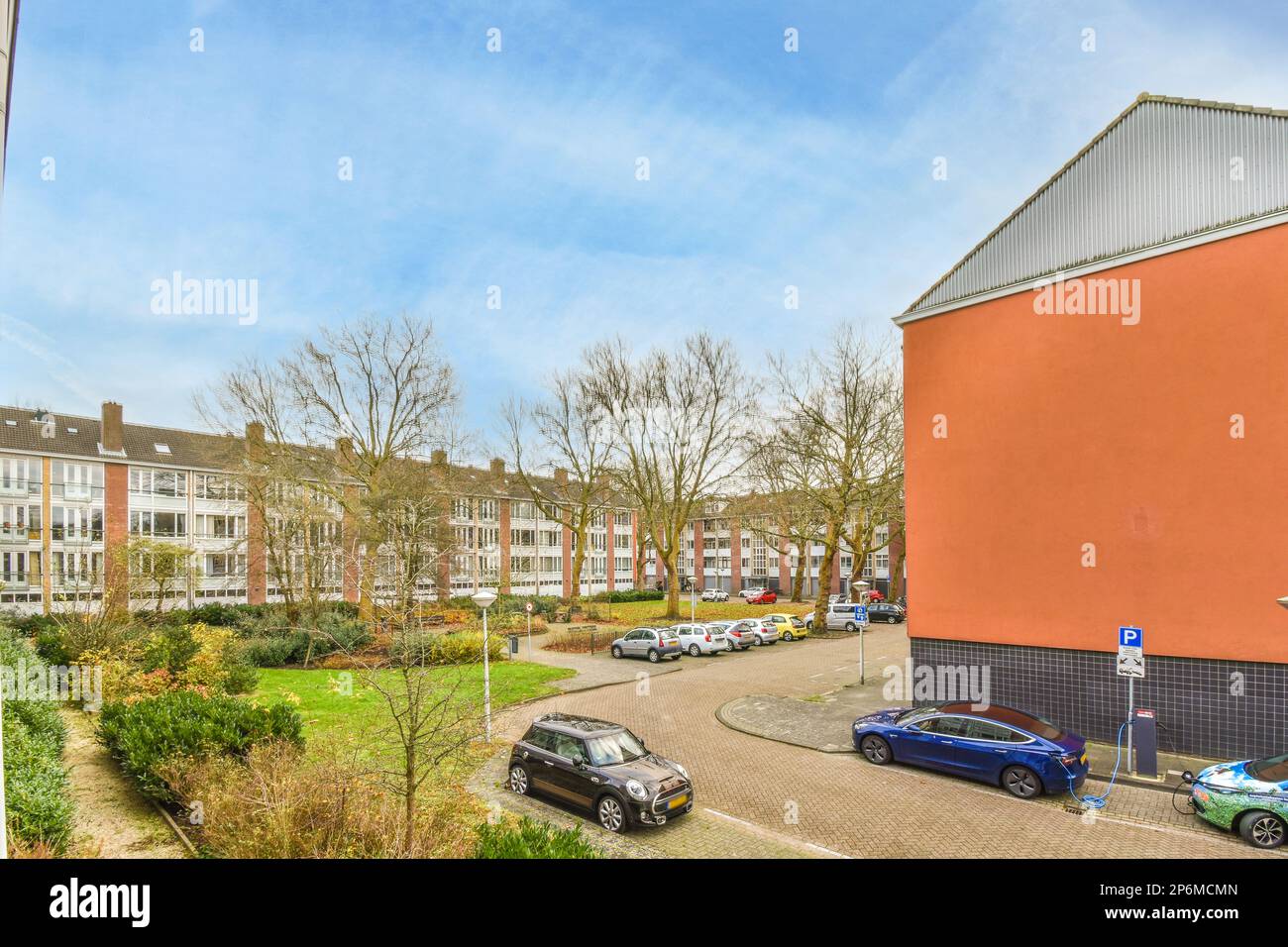 a street with cars parked on the side and buildings in the back ground ...