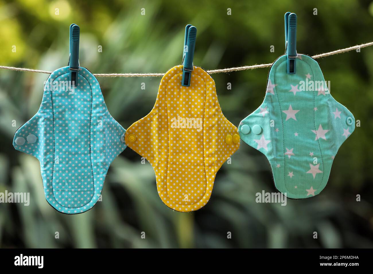 Many different menstrual cloth pads hanging on rope outdoors Stock
