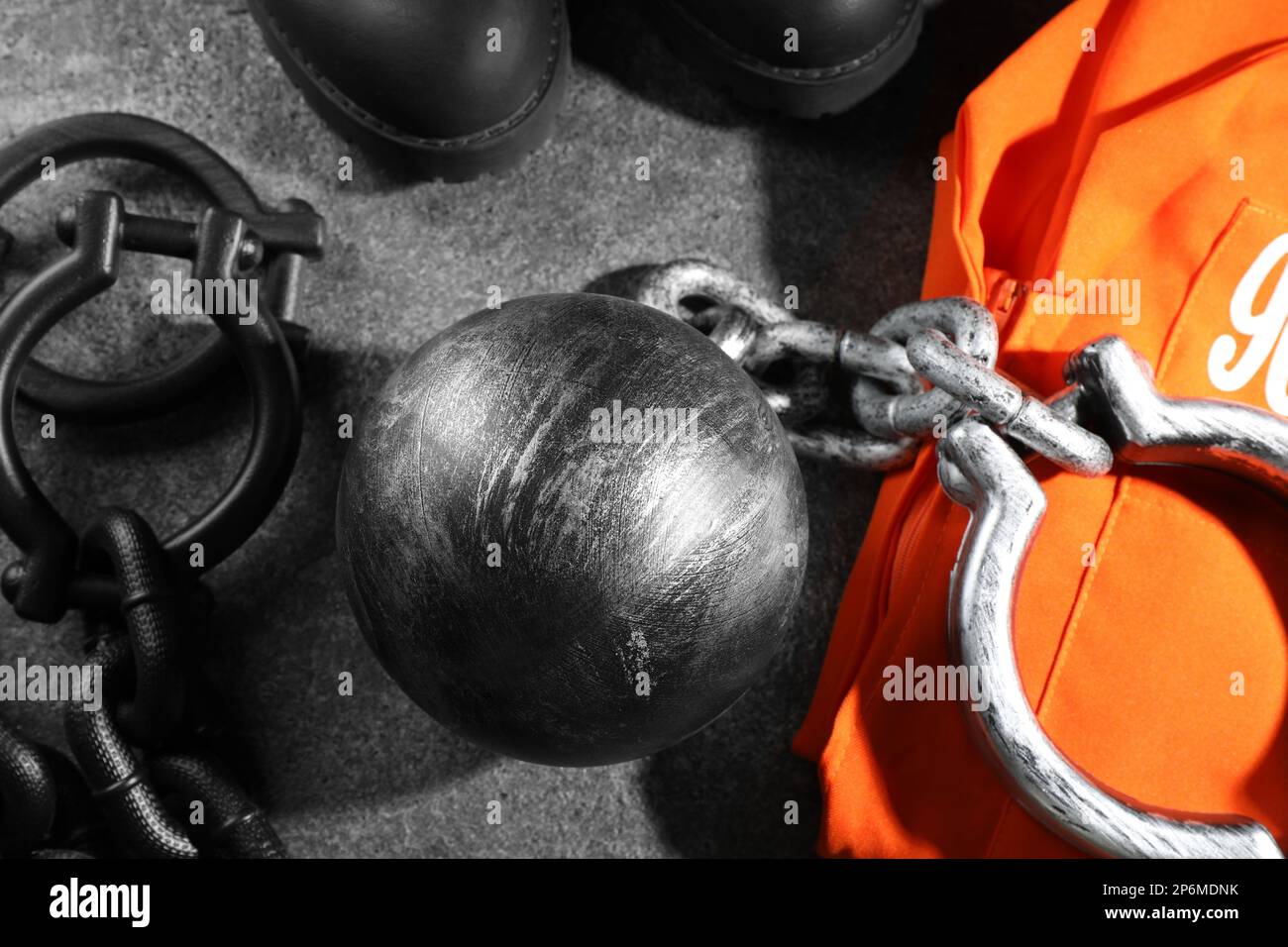 Prisoner ball with chain and jail clothes on grey table, flat lay Stock