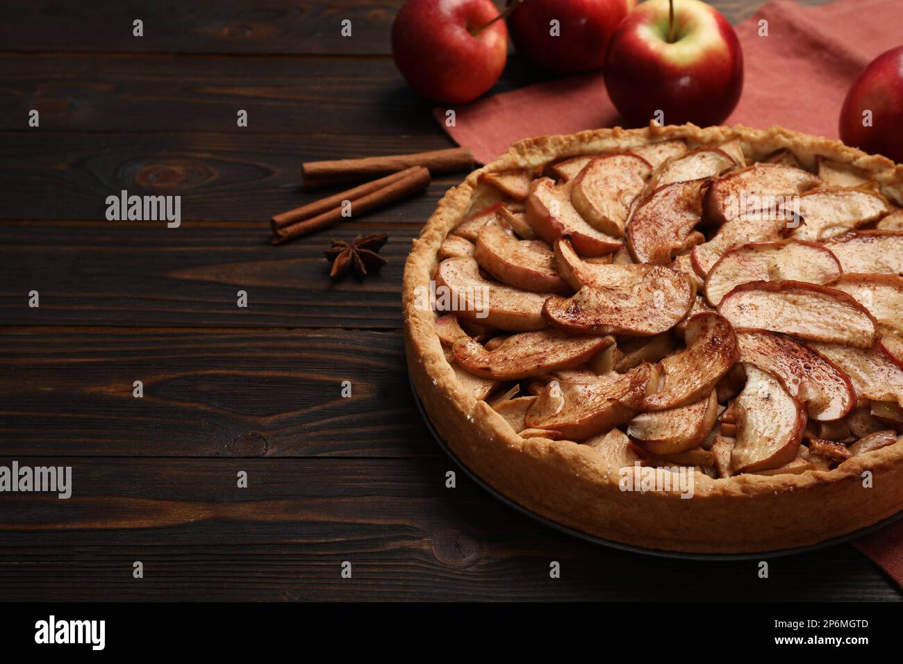 Delicious apple pie and ingredients on wooden table, space for text Stock Photo
