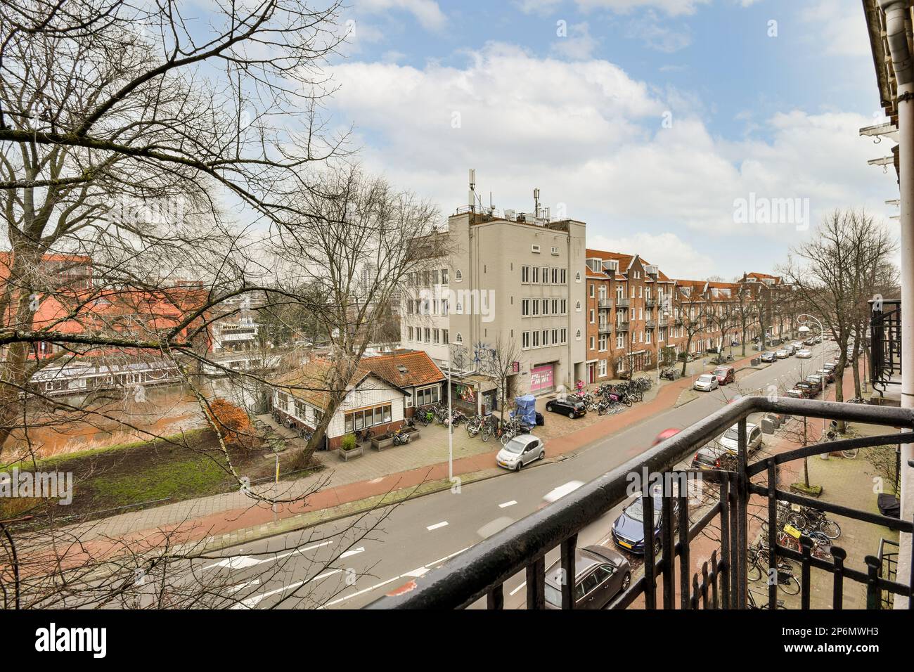 a city street with cars parked on the road and buildings in the ...