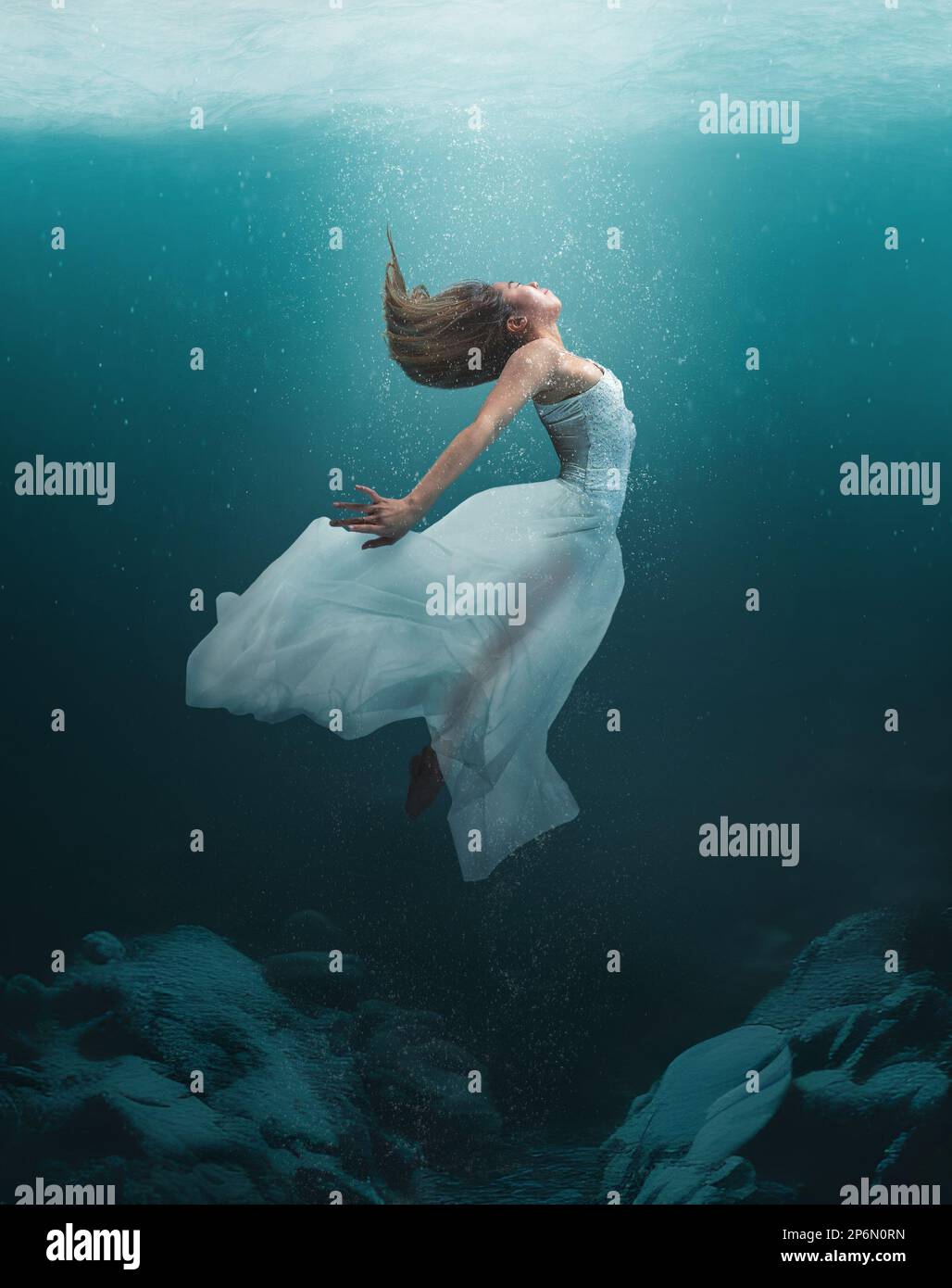 Beautiful girl in artistic dance underwater with flowing dress and