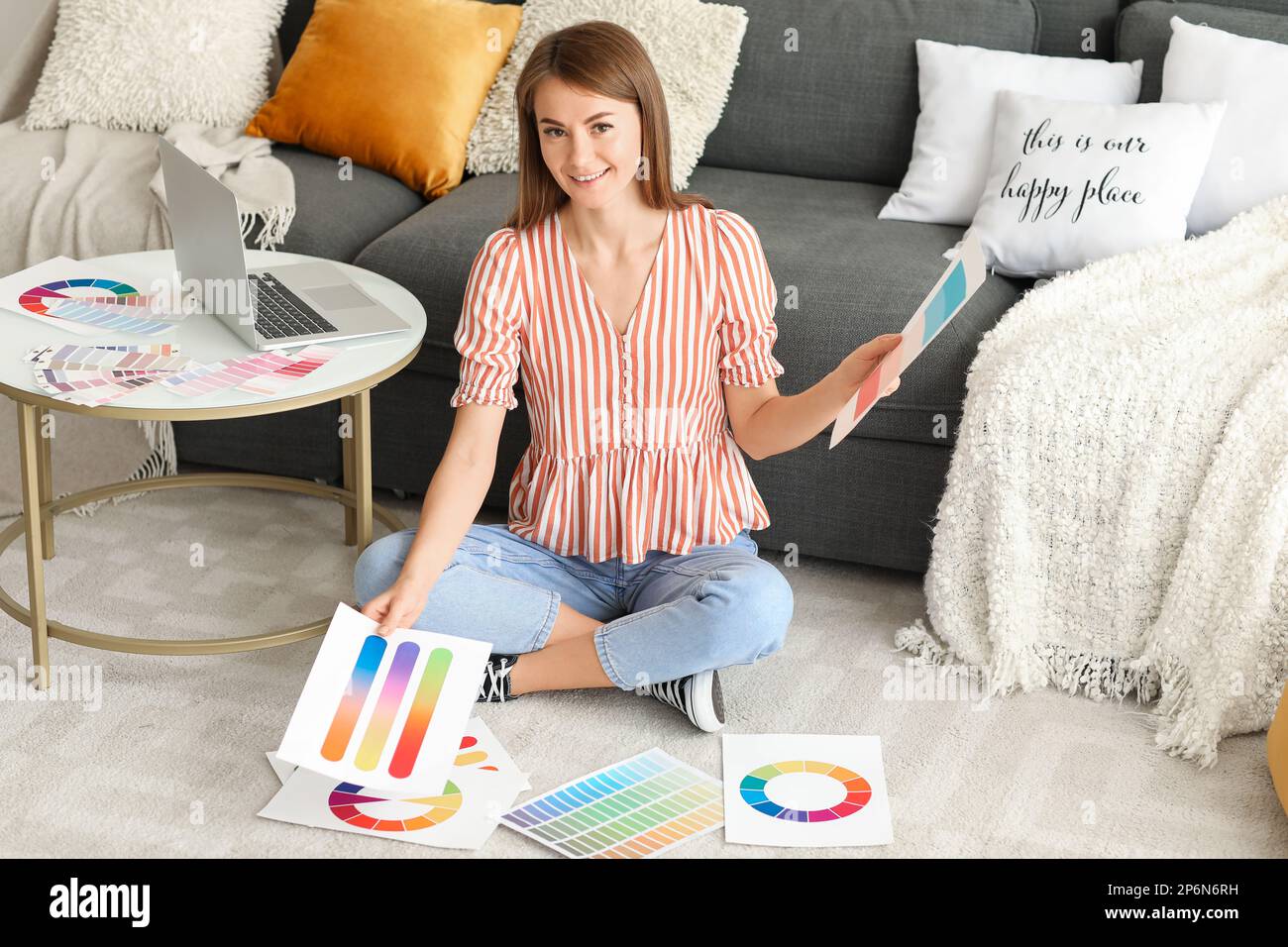 Young woman with paint color palettes sitting on floor at home Stock ...