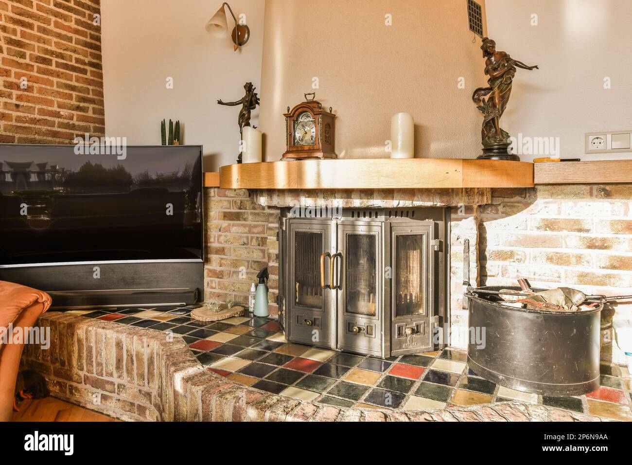 a living room with a brick fireplace and television set on the wall in front of the fireplace is made out of bricks Stock Photo