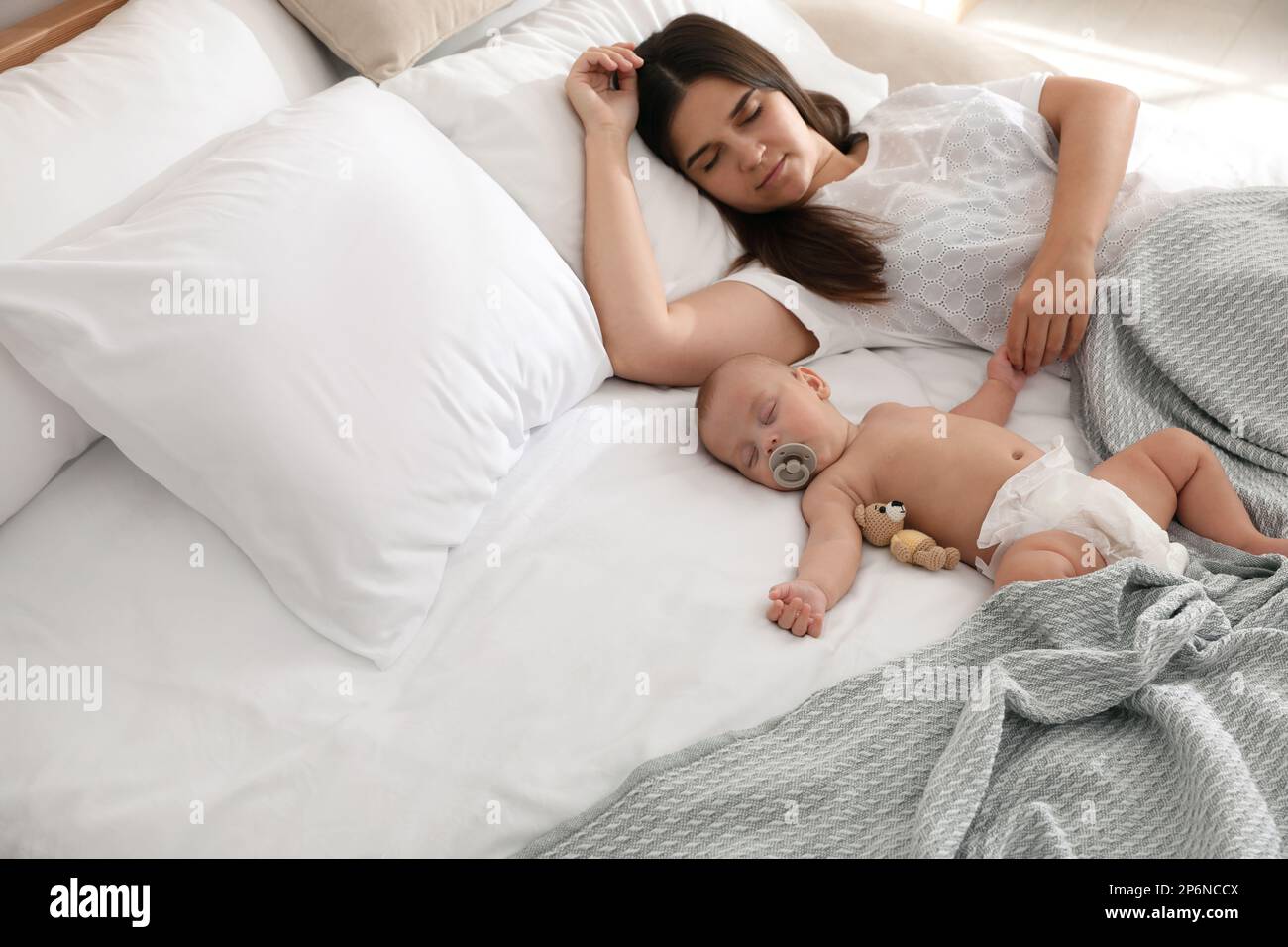 Mother with her cute baby sleeping in bed Stock Photo Alamy