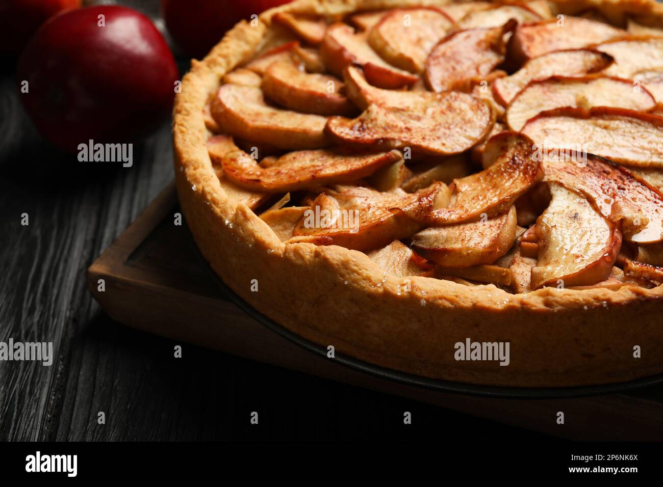 Delicious apple pie and fresh fruits on black wooden table, closeup Stock Photo