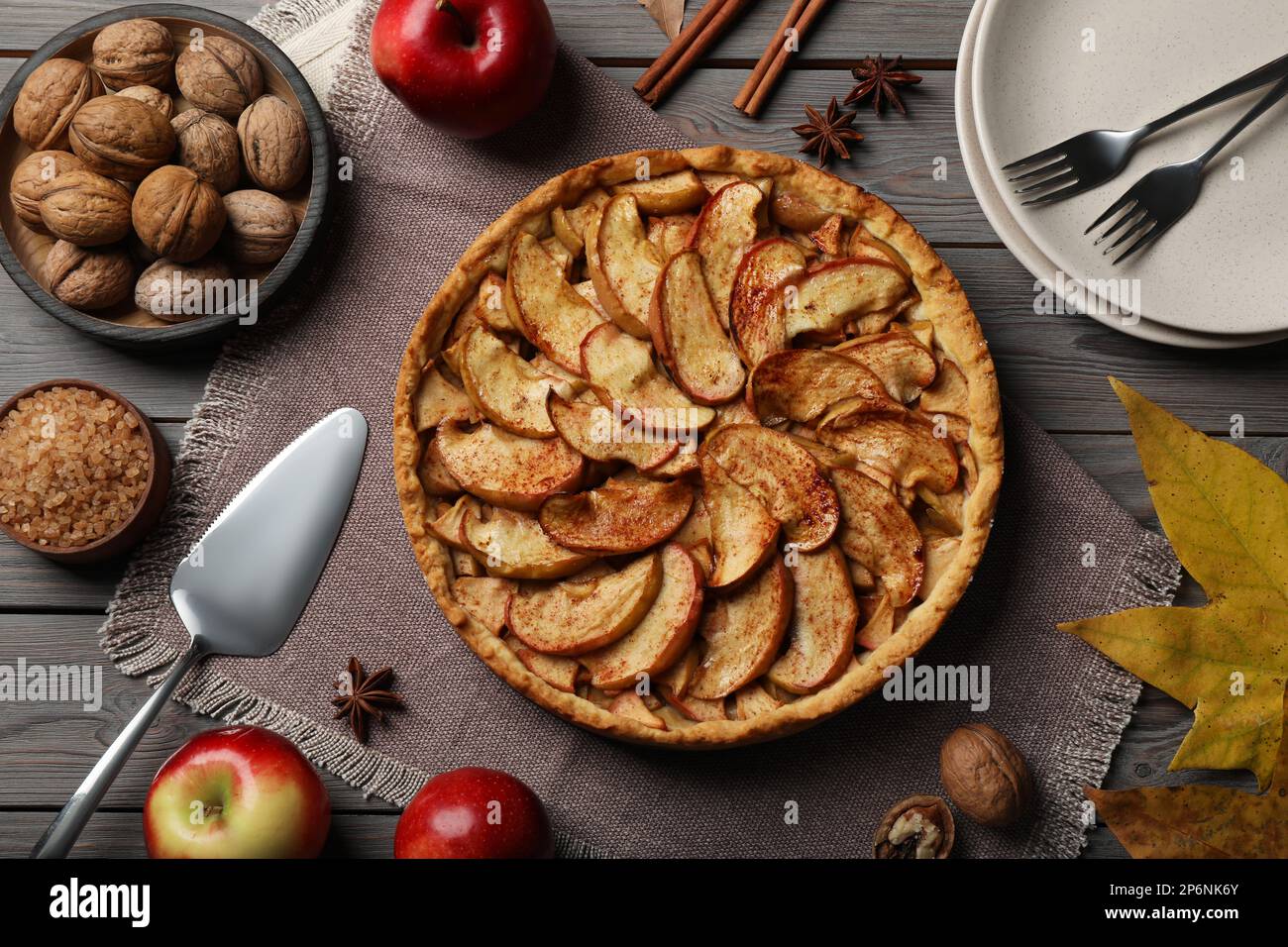 Delicious apple pie and ingredients on grey wooden table, flat lay Stock Photo