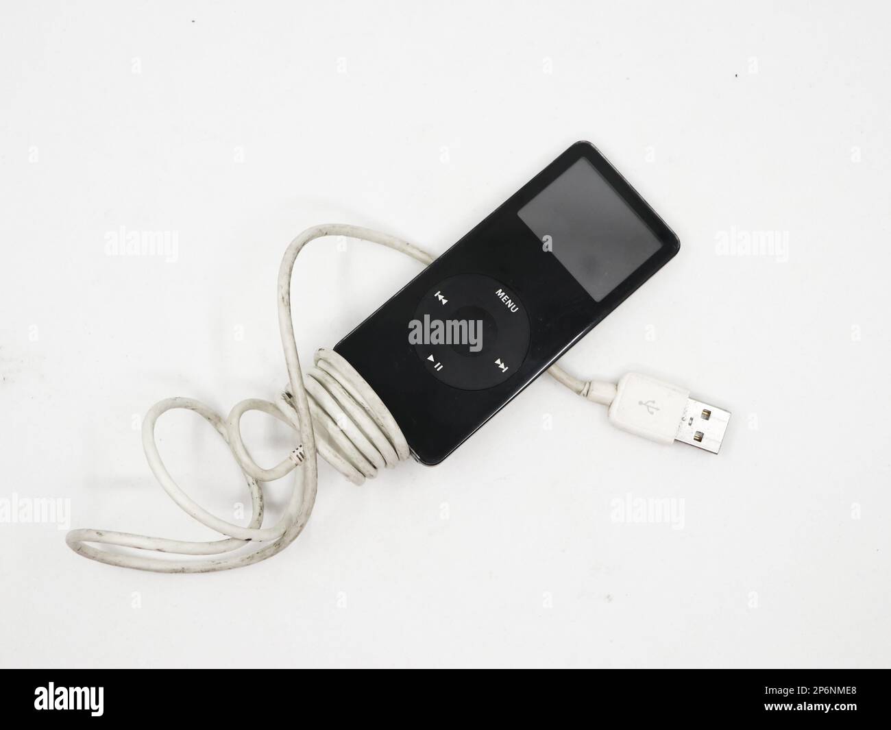 Closeup of a black vintage mp3 music player known as apple ipod nano with charging cable isolated in a white background Stock Photo