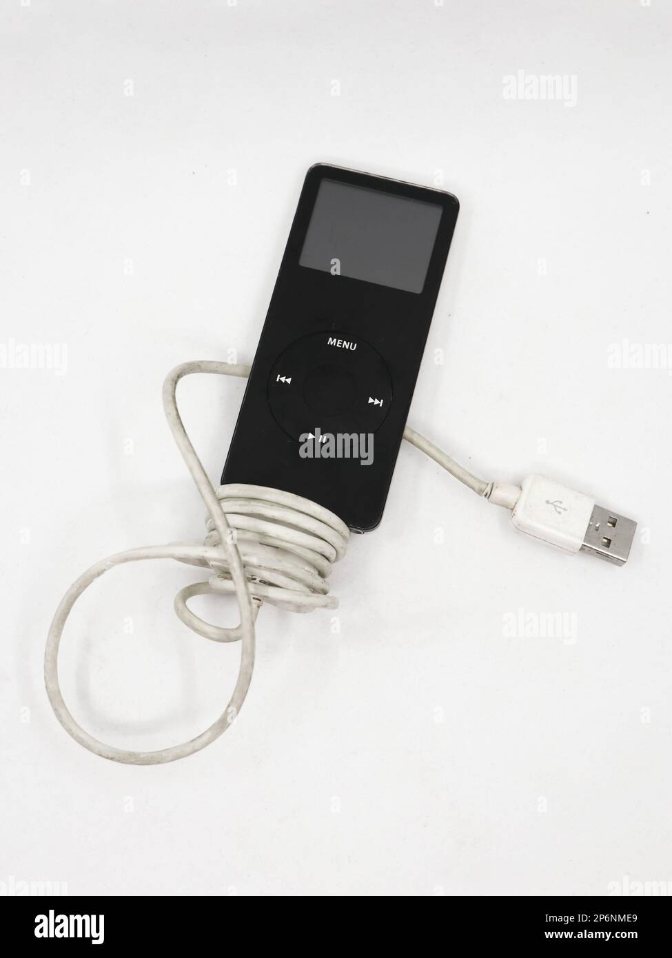 Closeup of a black vintage mp3 music player known as apple ipod nano with charging cable isolated in a white background Stock Photo