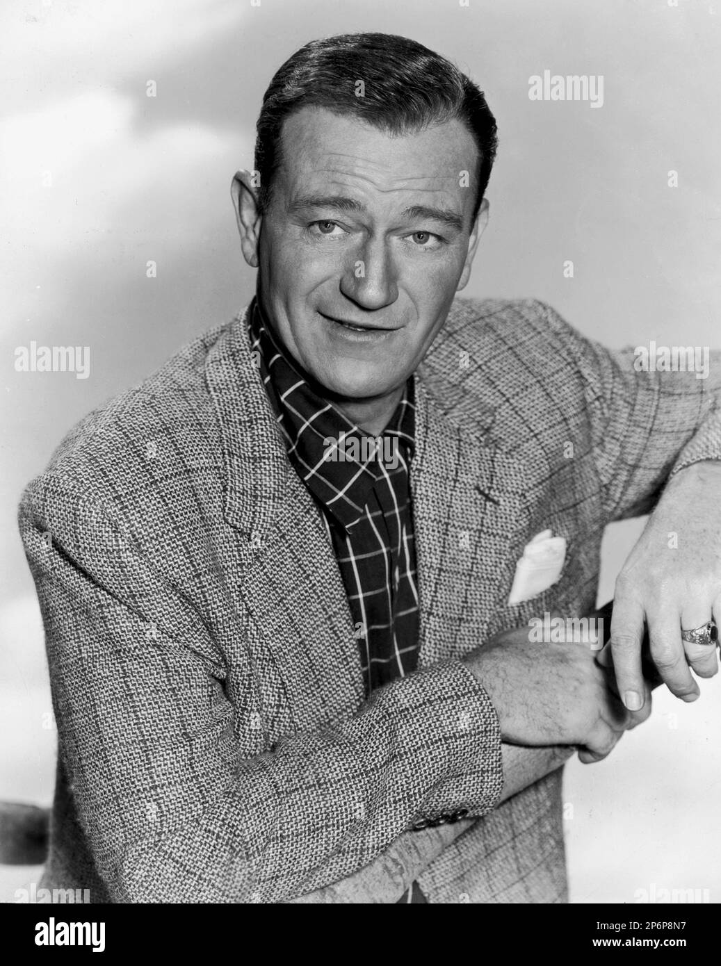 1956 ca : The  celebrated movie actor JOHN WAYNE  in a pubblicitary shot   - CINEMA - ATTORE CINEMATOGRAFICO - SMILE - SORRISO - pochette - fazzoletto nel taschino  ----  Archivio GBB Stock Photo