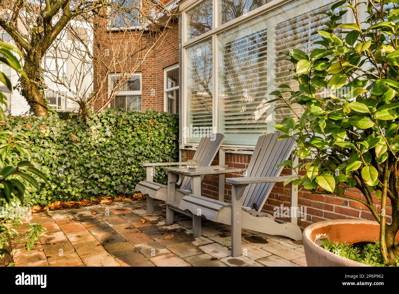 an outside area with a bench and potted plant on the ground in front of ...
