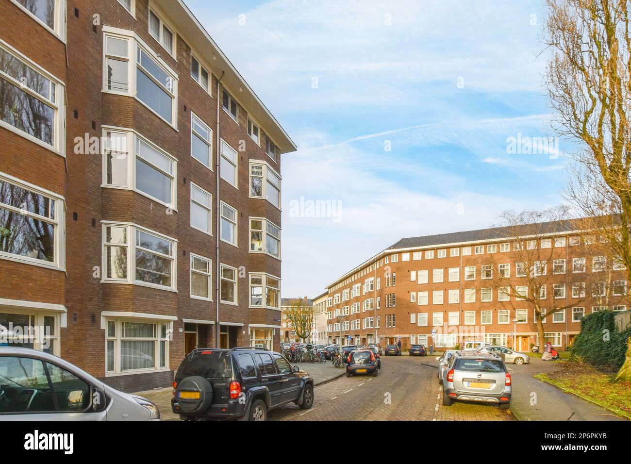 a street with cars parked on the side and buildings in the back ground ...