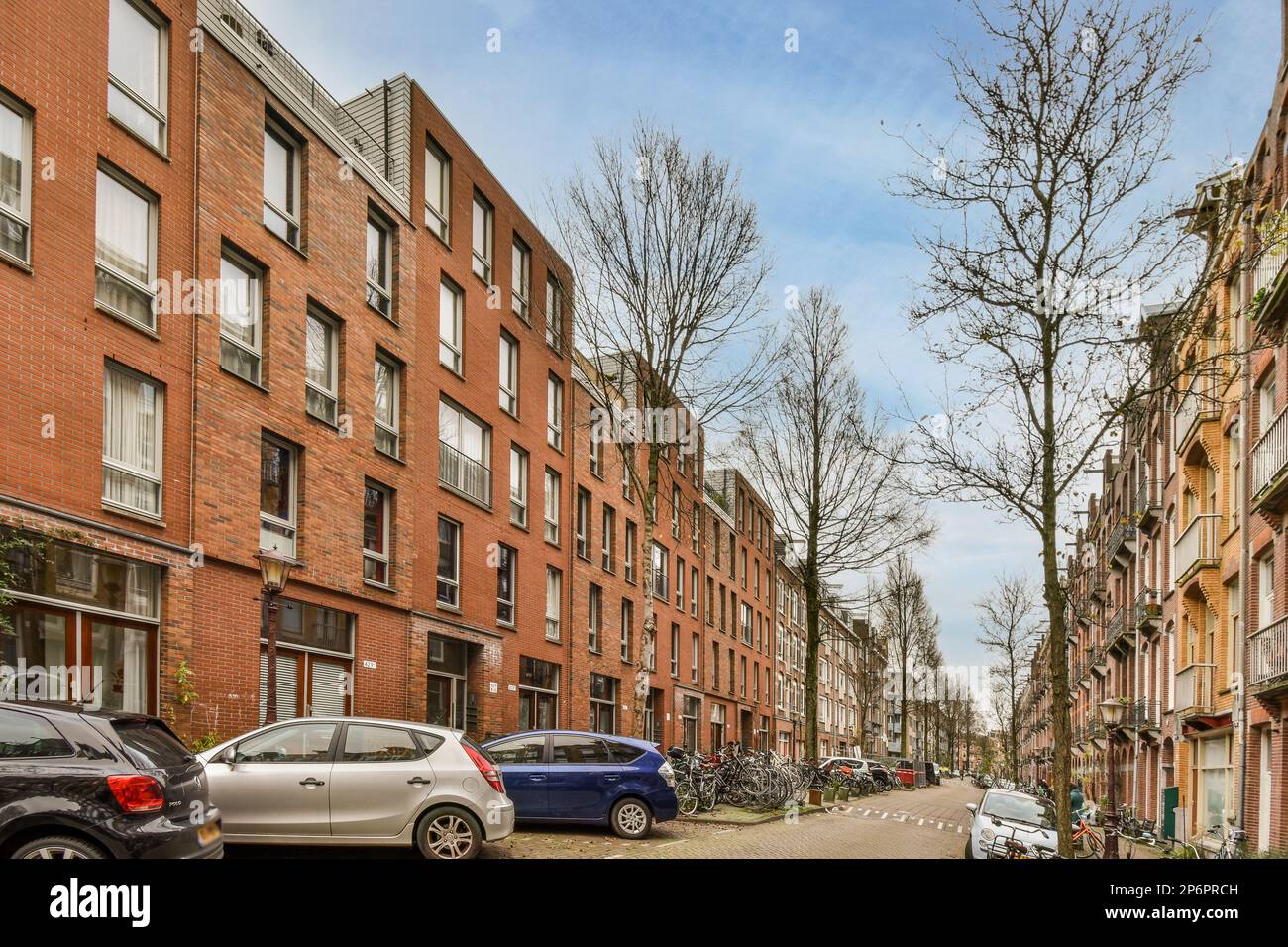 some cars parked on the side of a street in an urban area with tall ...