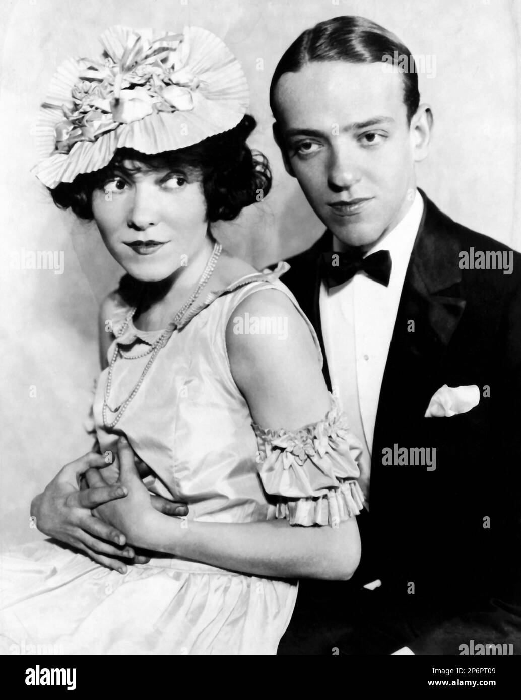 1933 ca  :  The  movie actor and dancer FRED ASTAIRE ( 1899 - 1987 ) with his sister ADELE ASTAIRE ( married in 1932 with Lord Charles Cavendish )  in a pubblicitary shot  - CINEMA - ATTORE CINEMATOGRAFICO  - tie  - cravatta - papillon - bow tie - grease - brillantina  - fazzoletto nel taschino - pochette - DANZA - DANCE - ballerino - TIP TAP - fratello e sorella - brother - hat - cappello - neclace - collana - bijoux - abbraccio - embrace   ---- Archivio GBB Stock Photo