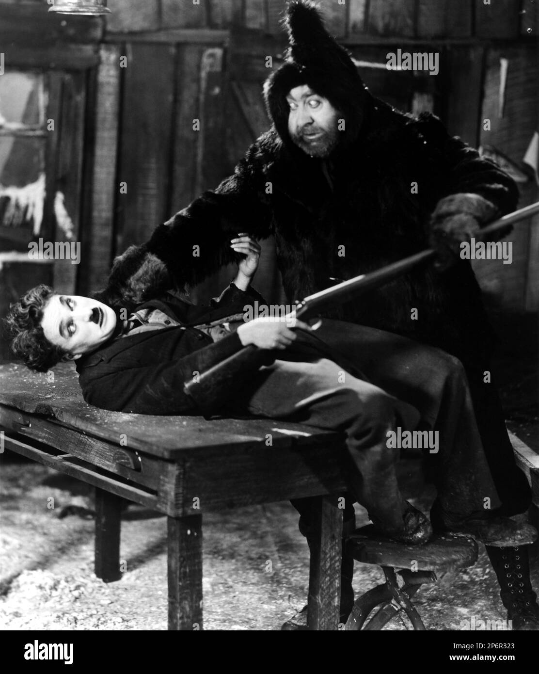 1925 : The silent movie actor and movie director CHARLES CHAPLIN ( 1889 - 1977 ) with Mack Swain in THE GOLD RUSH ( La febbre dell' oro ) - CINEMA - FILM - portrait - ritratto - regista cinematografico - attore - attrice - comico - fucile - gun - lotta - fight  ---- Archivio GBB      Archivio Stock Photo