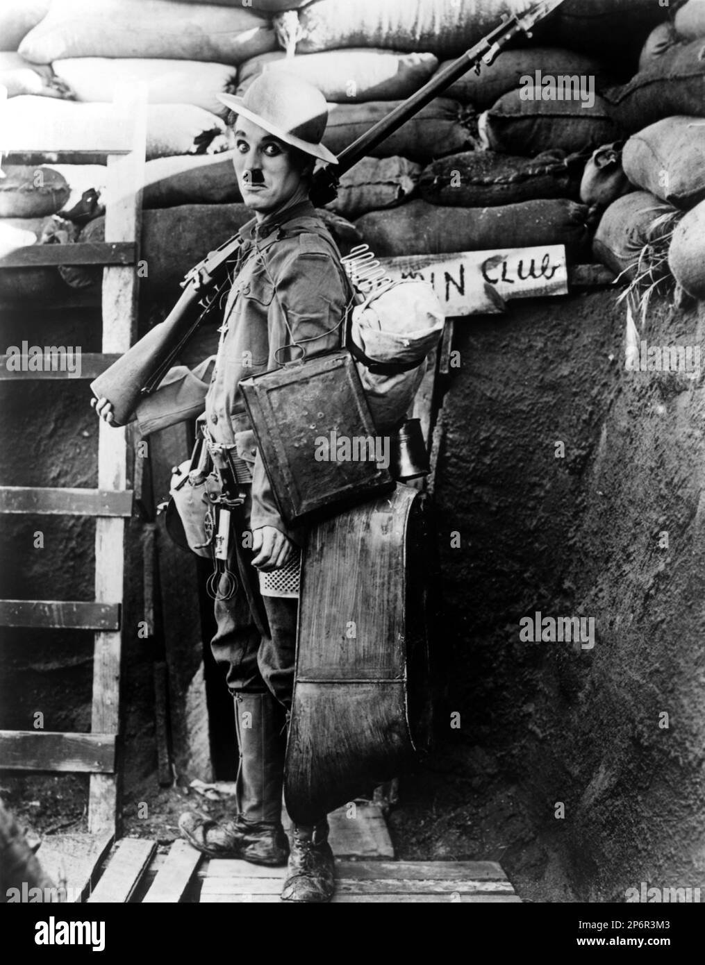 1918 , USA: The silent movie actor and movie director CHARLES CHAPLIN ( 1889 - 1977 ) SHOULDER ARMS . - CINEMA MUTO - FILM - portrait - ritratto - regista cinematografico - attore - comico - fucile - gun -arma - military uniform - divisa uniforme militare - trincea - WWI - PRIMA GUERRA MONDIALE - baffi - moustache  - helmet - elmetto ---- Archivio GBB      Archivio Stock Photo