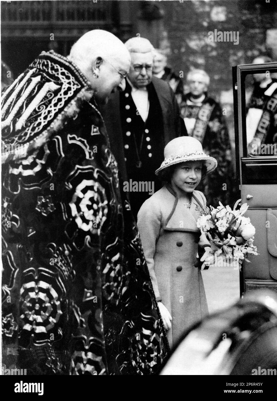1935 , 18 april , London , GREAT BRITAIN : The princess  ELIZABETH ( future Queen ELIZABETH II of England ,  born 1926 ),  performed the ceremony of distributing Neundy Thursday money at Westminster Abbey , in this photo with the Bishop of Canterbury  .- REALI - ROYALTY - nobili - nobiltà - nobility - GRAND BRETAGNA - GREAT BRITAIN - INGHILTERRA - REGINA - WINDSOR - House of Saxe-Coburg-Gotha - celebrity personality celebrities personalities when was young little child children - celebrità personalità da giovani giovane piccoli piccoli bambini bambino bambina - hat - cappello   ---- Archivio G Stock Photo
