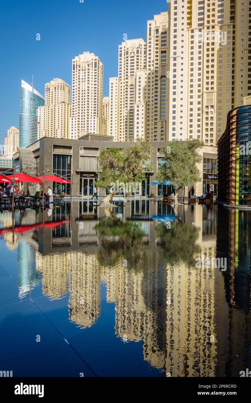 Dubai, UAE, February 23, 2018: Jumeirah Beach Residence (JBR) highrise apartment buildings reflected in a pons at a popular shopping and entertainment Stock Photo