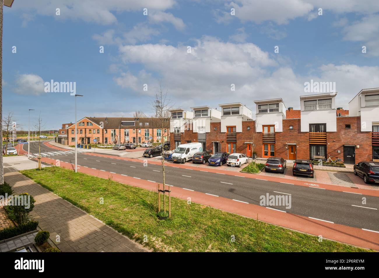 a street with cars parked on the side and buildings in the back ground ...