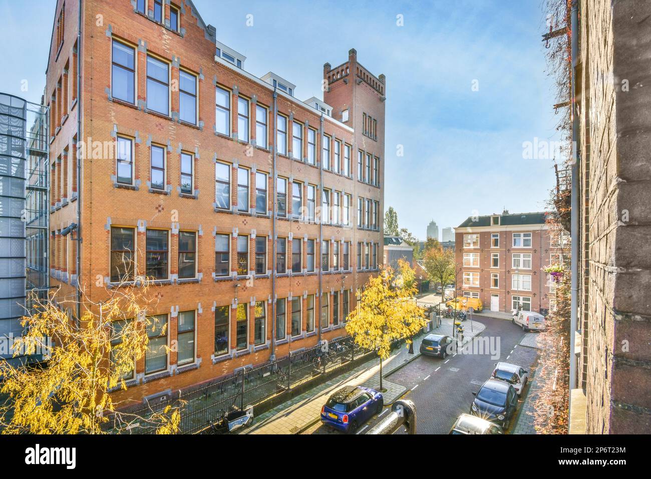 a city street with cars parked on the side and buildings in the ...