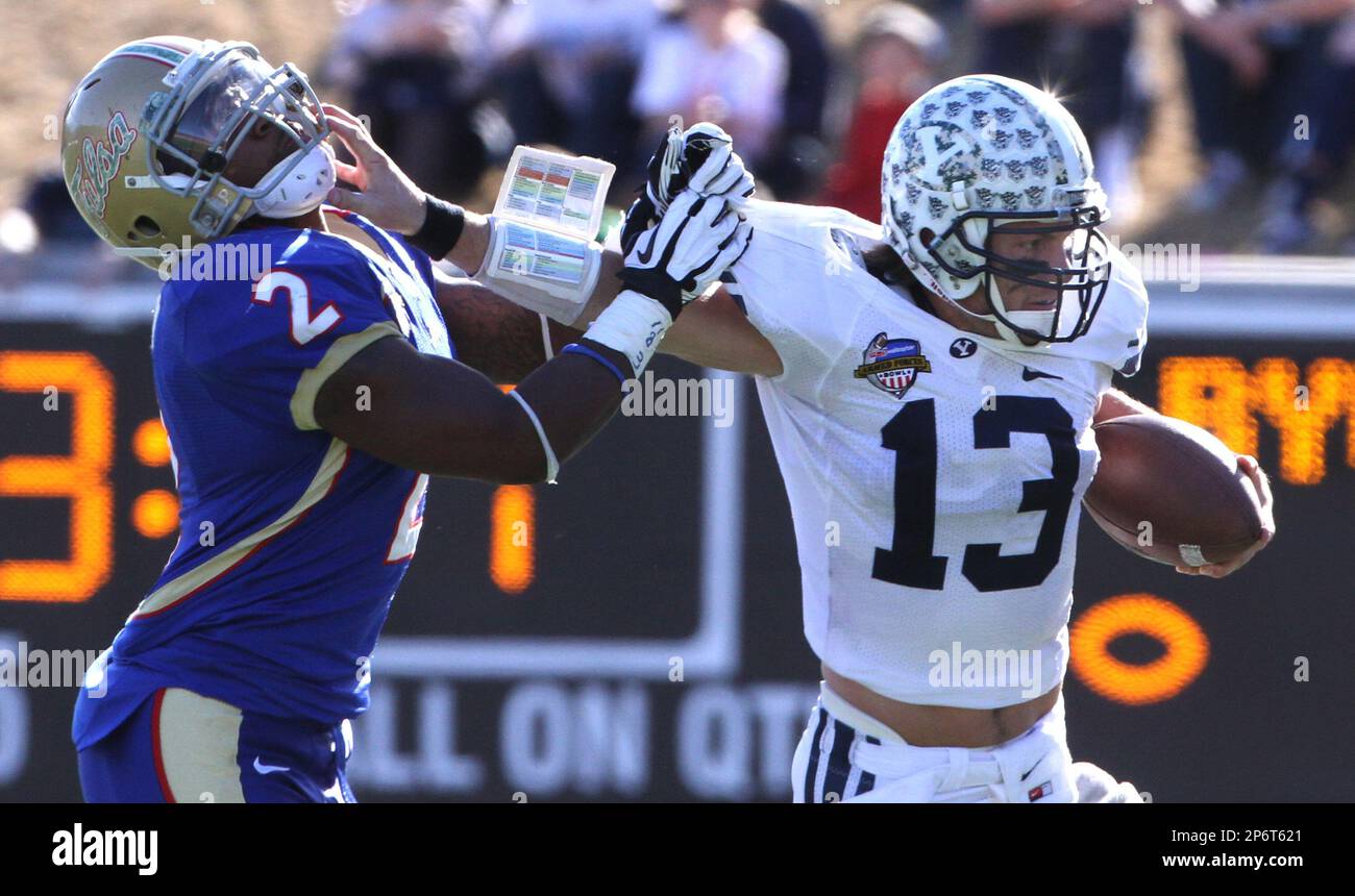 Brigham Young Cougars quarterback Riley Nelson (13) stiff arms Tulsa Golden Hurricane linebacker