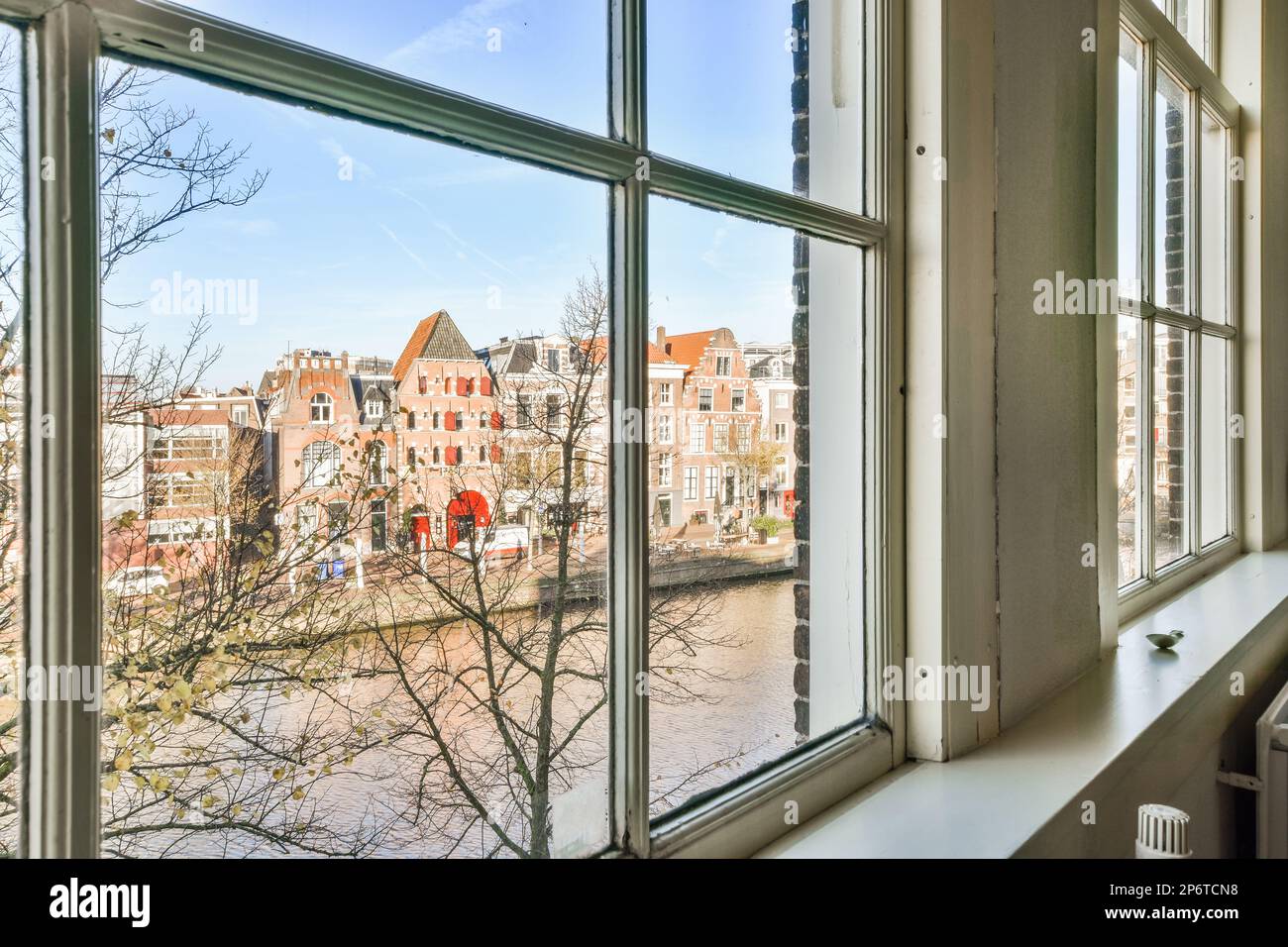 a view from a window in an old building with no leaves on the tree ...