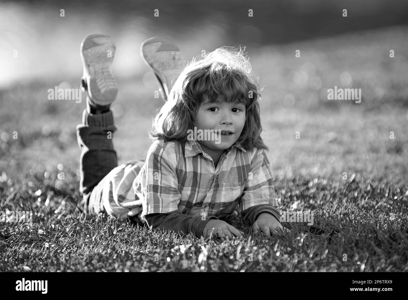 Child outdoor. Kid in park. Spring Boy lying on grass. Summer walk