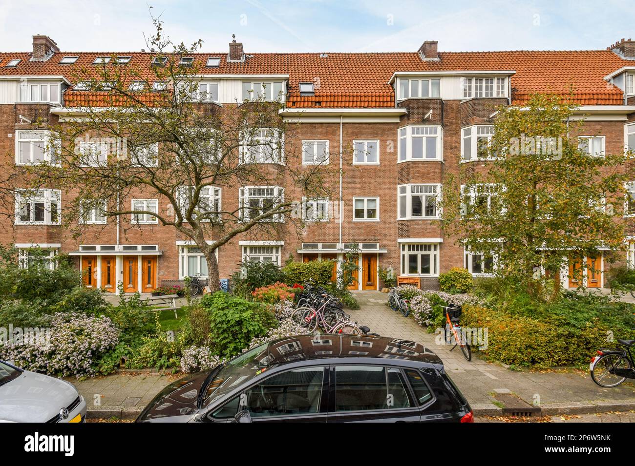 an apartment complex with cars parked on the street and bicycles parked ...