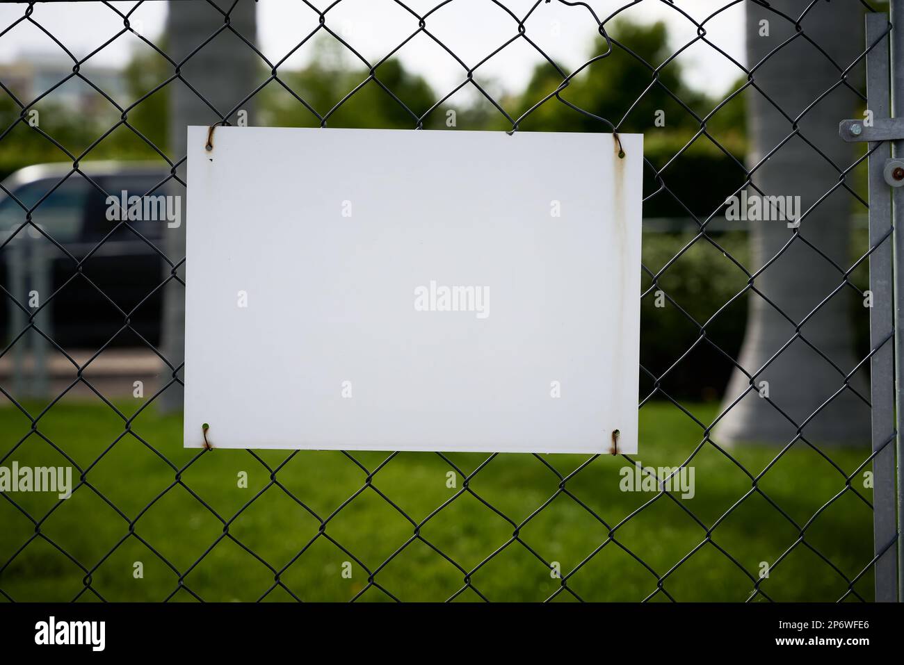 blank white unlabeled sign with text space on a fence Stock Photo