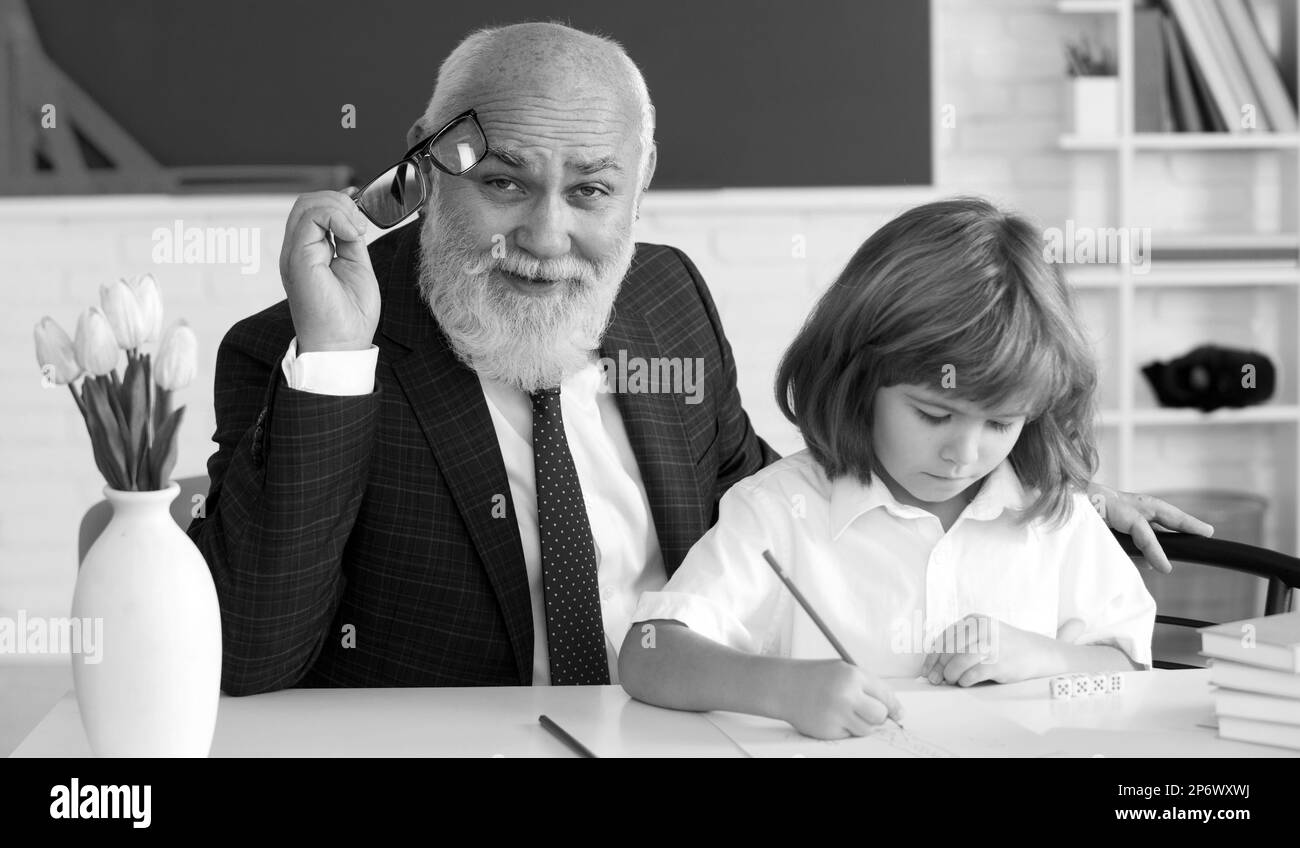 Help to learn. Old teacher with pupil. School lesson. Education concept. Old teacher with