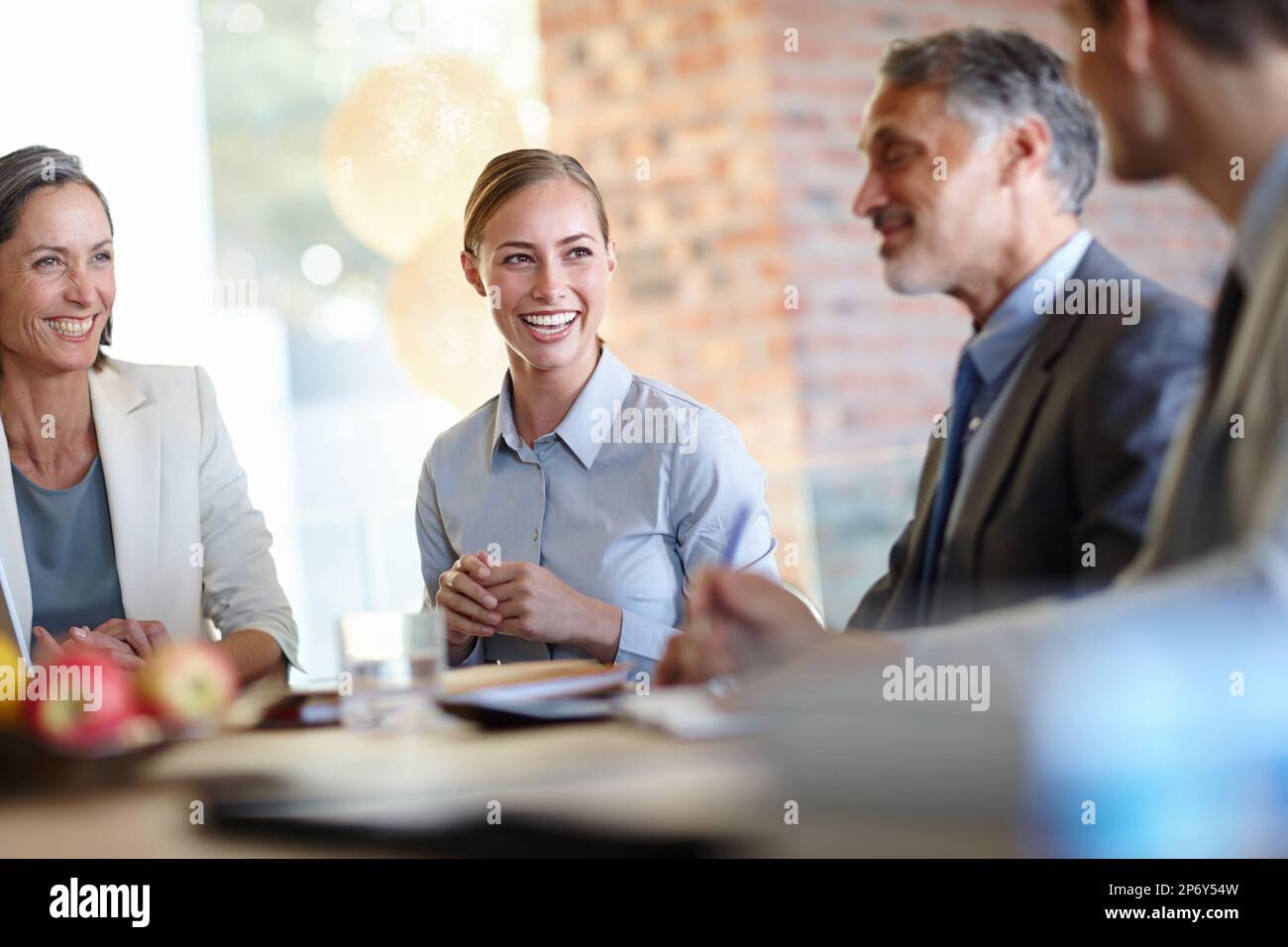 Our boss, the joker. A cropped shot of a group of happy businesspeople having a meeting. Stock Photo