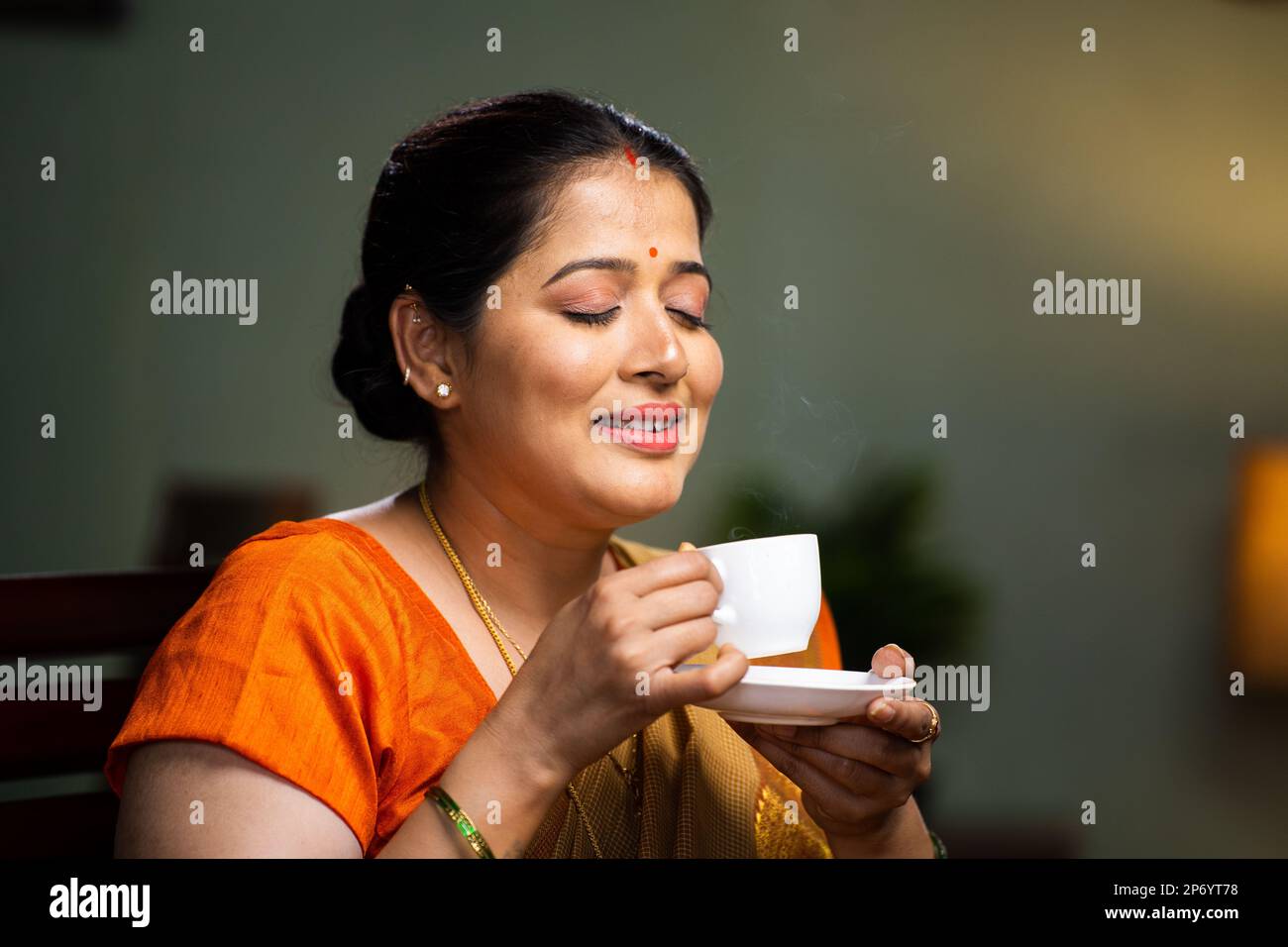 Relaxed woman enjoying drinking tea or coffee at home during morning at home - concept of calmness, serene and wellbeing Stock Photo