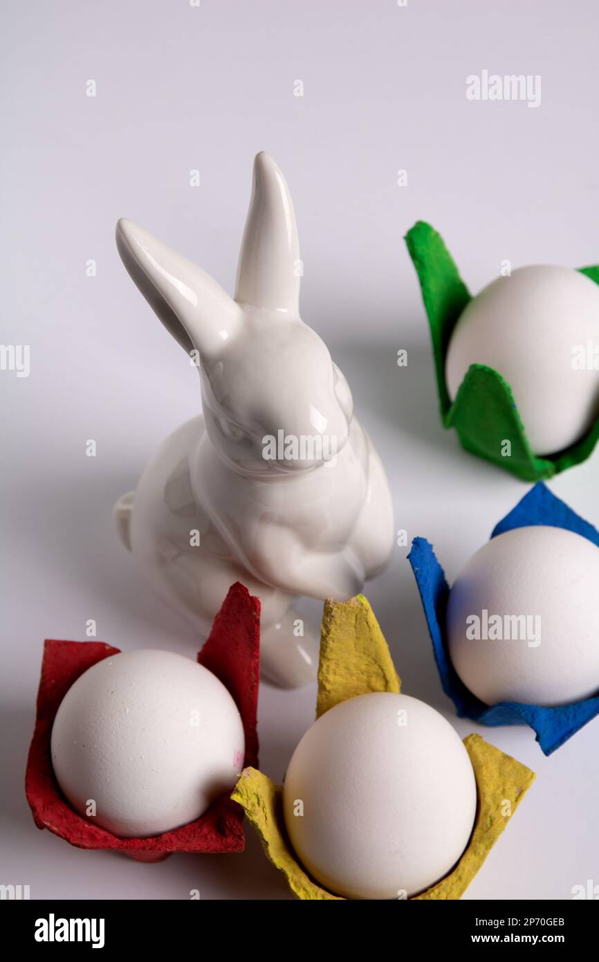 photo rabbit and multicolored egg carton with eggs on white background Stock Photo