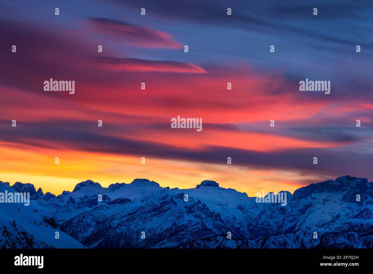 Picture of some spectacular colorful clouds over Mount Marmolada at sunset in Cortina d'Ampezzo, Italy Stock Photo