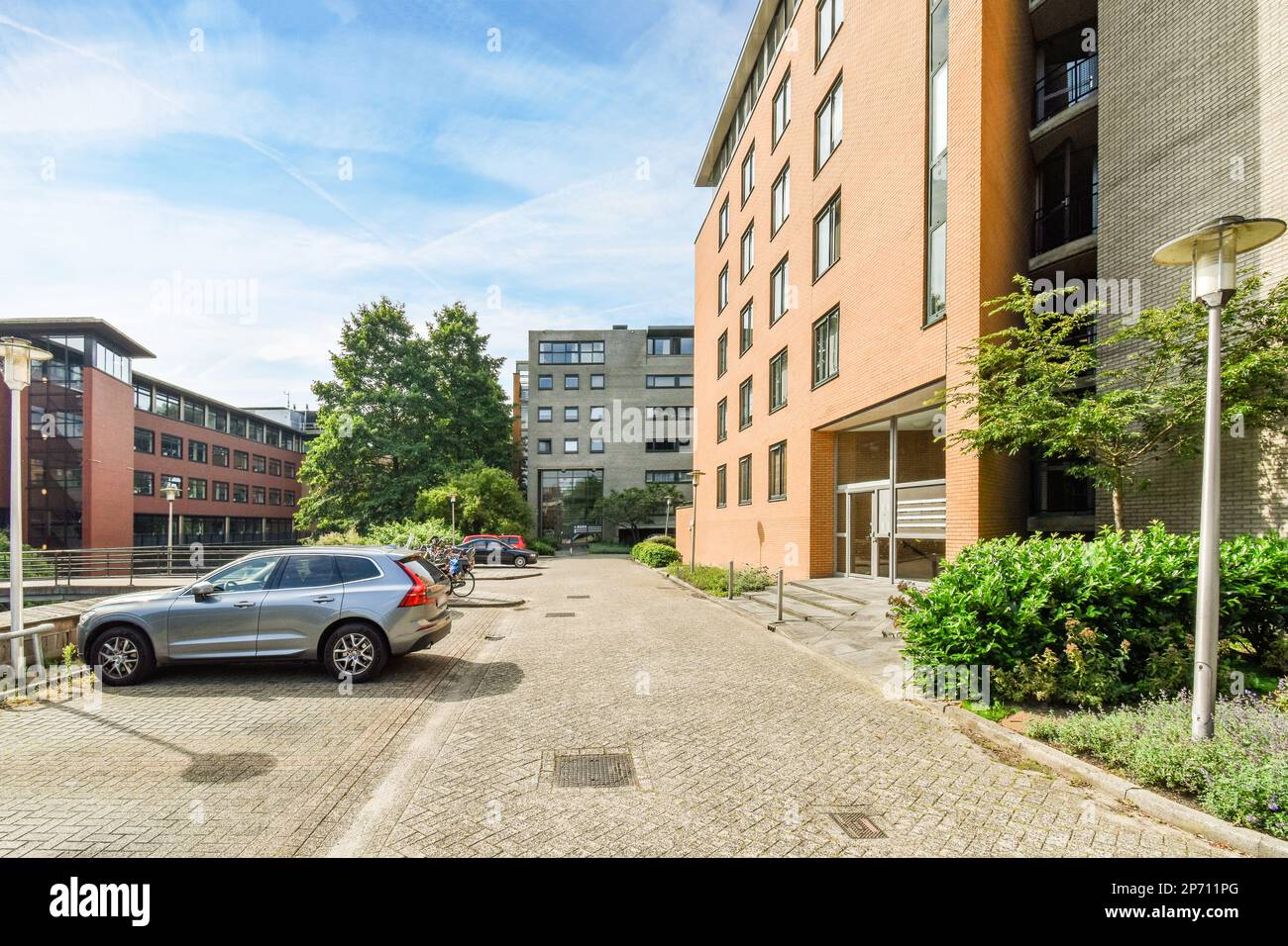 a city street with cars parked on the side and buildings in the back ...