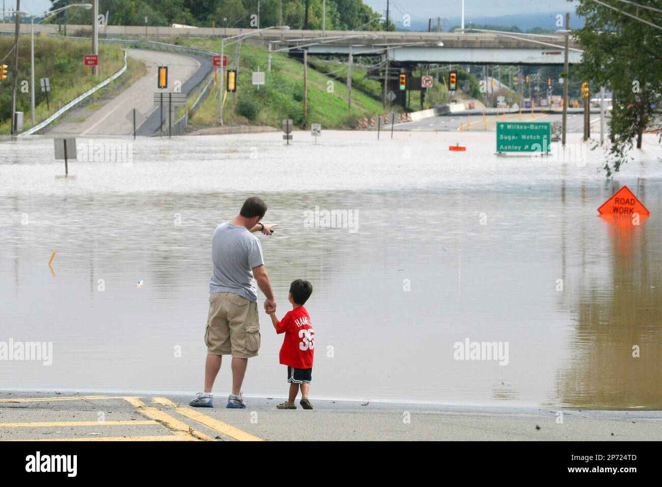 Jim Pyrah points out to the floodwater from the remnants of Tropical Storm  Lee as his son Cole Pyrah, 5, looks out onto the San Souci Highway near the  border of Hanover