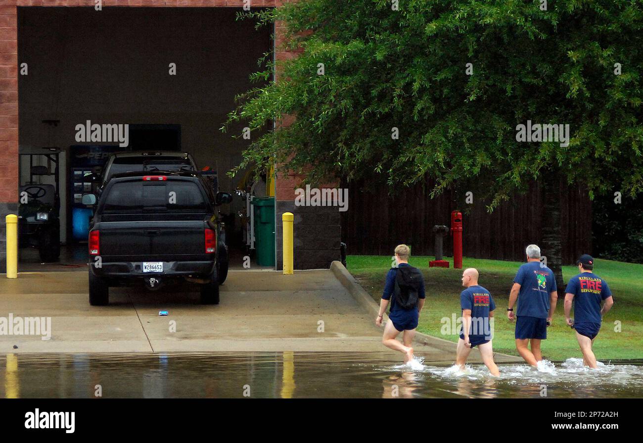 Ridgeland firefighters wade across a flooded Rice Road near Conestoga