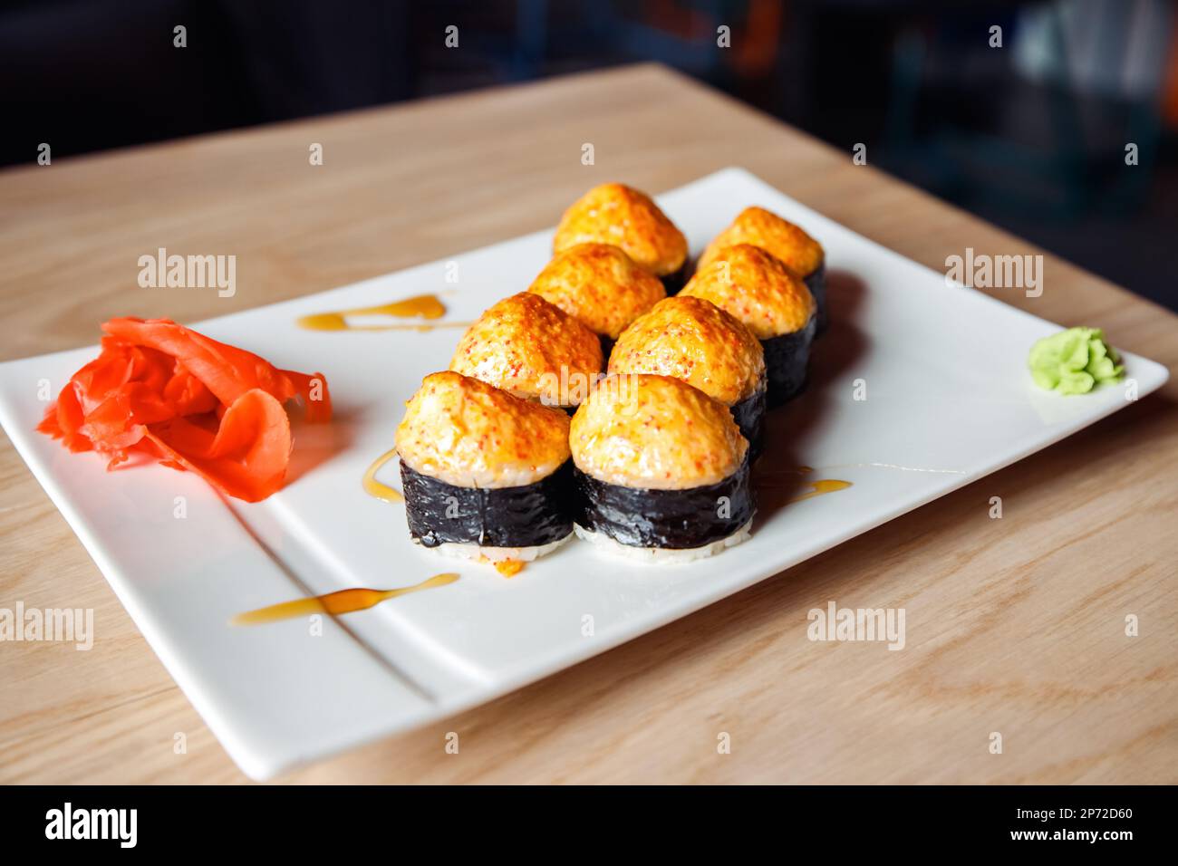 Baked Maki sushi, baked rolls on white rectangular plate. Eel, rice