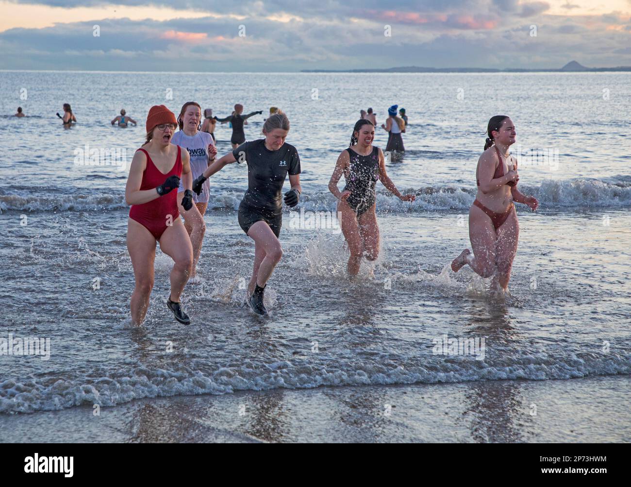 Portobello, Edinburgh, Scotland, UK. 8th March 2023. International Women’s Day swimrise dip 2023 carried on in minus 5 degree temperatures. Due to the extreme cold weather forecast and with advice from members of the RNLI safety team, organisers made the difficult decision to cancel the International Women’s Day swimrise dip 2023 was made yesterday however hundreds turned up at the beach. Credit: Archwhite/alamy live news. Stock Photo