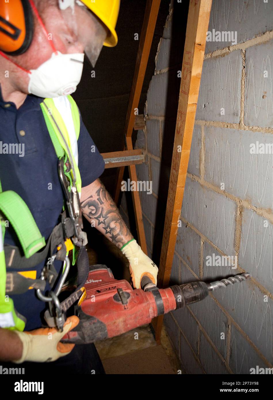 Illustrative image of cavity wall insulation. A worker from Total