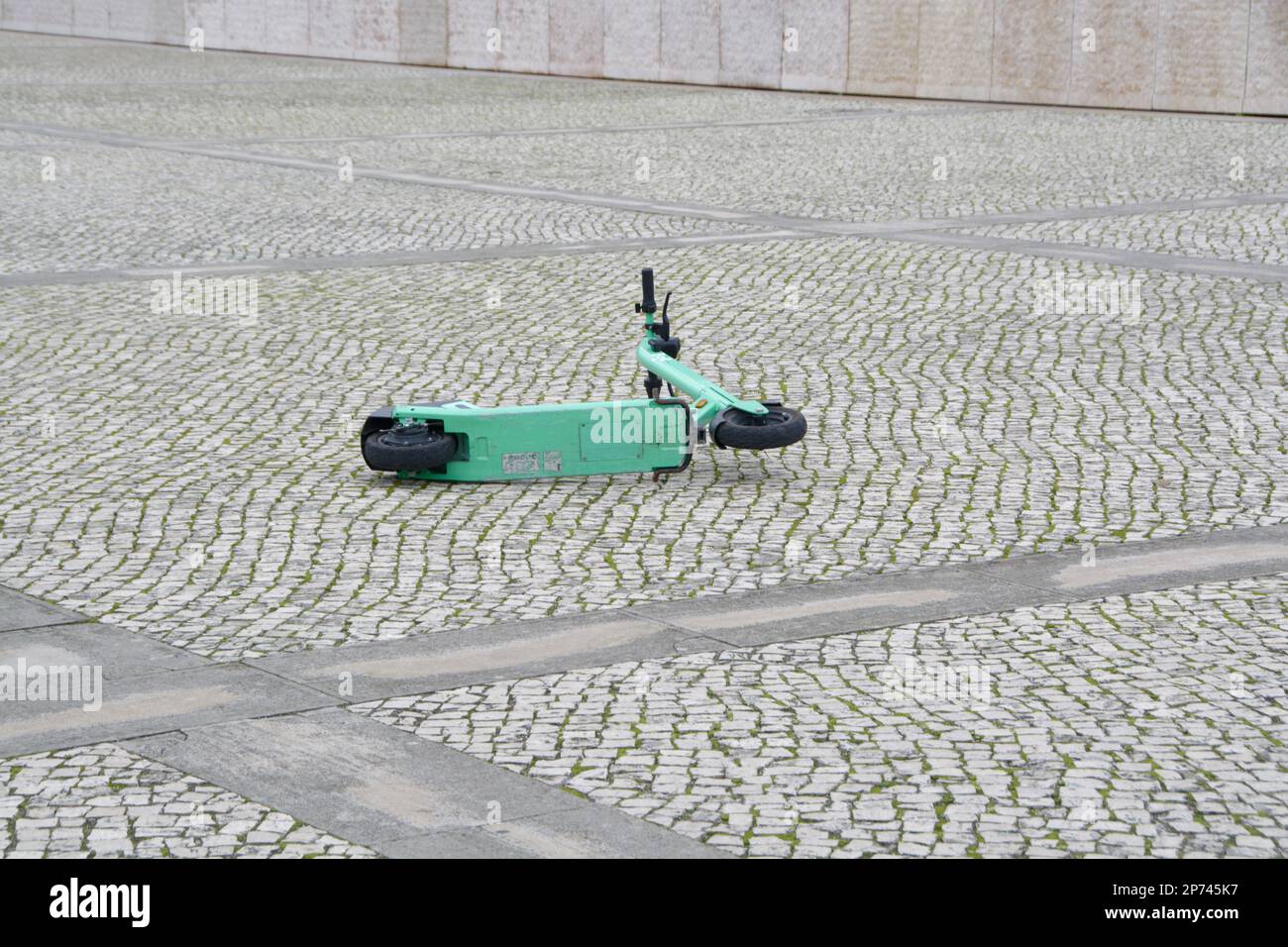 A Lone Green Electric Scooter lies on the paving outside the Cultural Centre of Belem. Is scooter clutter becoming a problem in tourist cities? Stock Photo