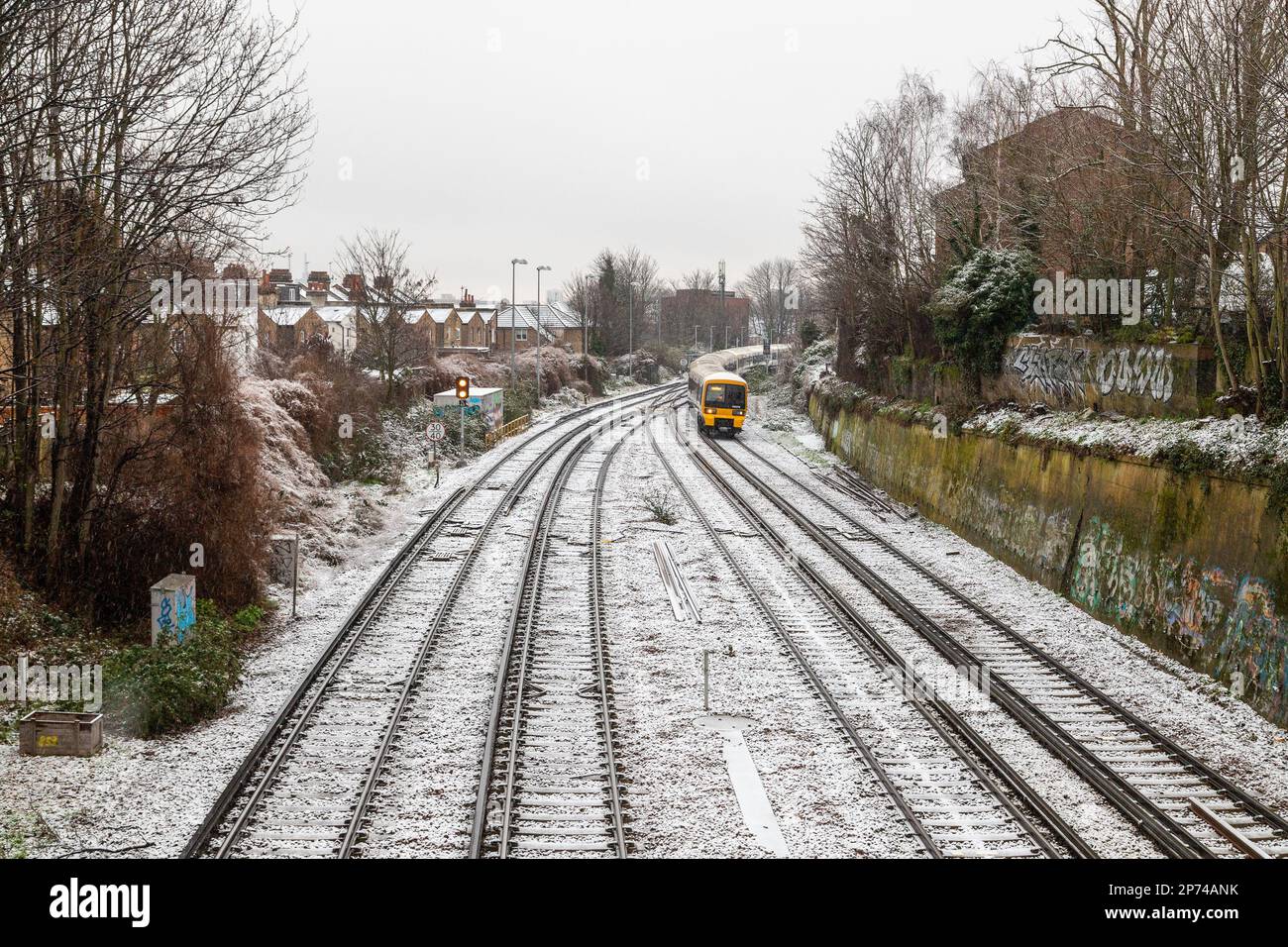 LONDON, UK - 8TH MAR 2023: A train on the railways in London during a snowy winter day. Stock Photo