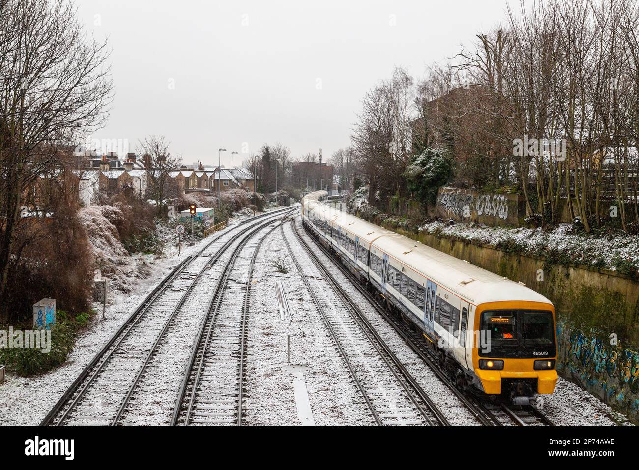 LONDON, UK - 8TH MAR 2023: A train on the railways in London during a snowy winter day. Stock Photo
