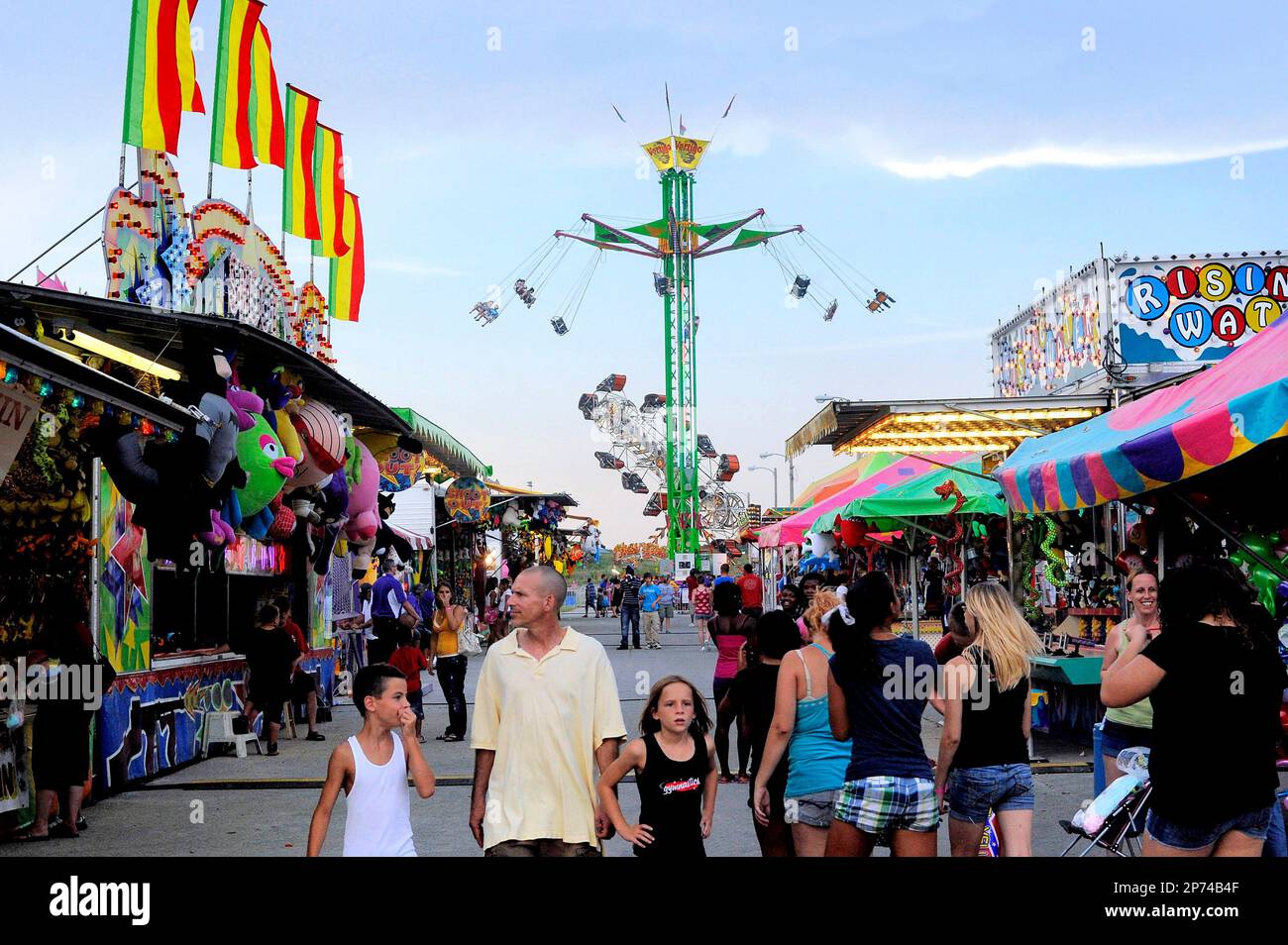 In this photo taken July 22, 2011, Boone County Fair attendees walk past vendors and rides in