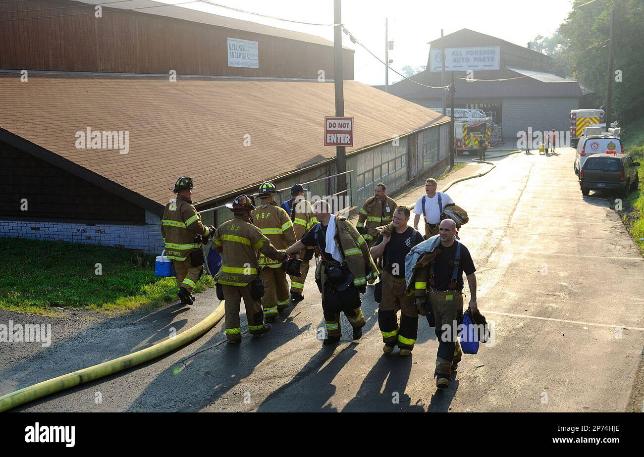 Firefighters slap hands while passing each other on the driveway of D&D