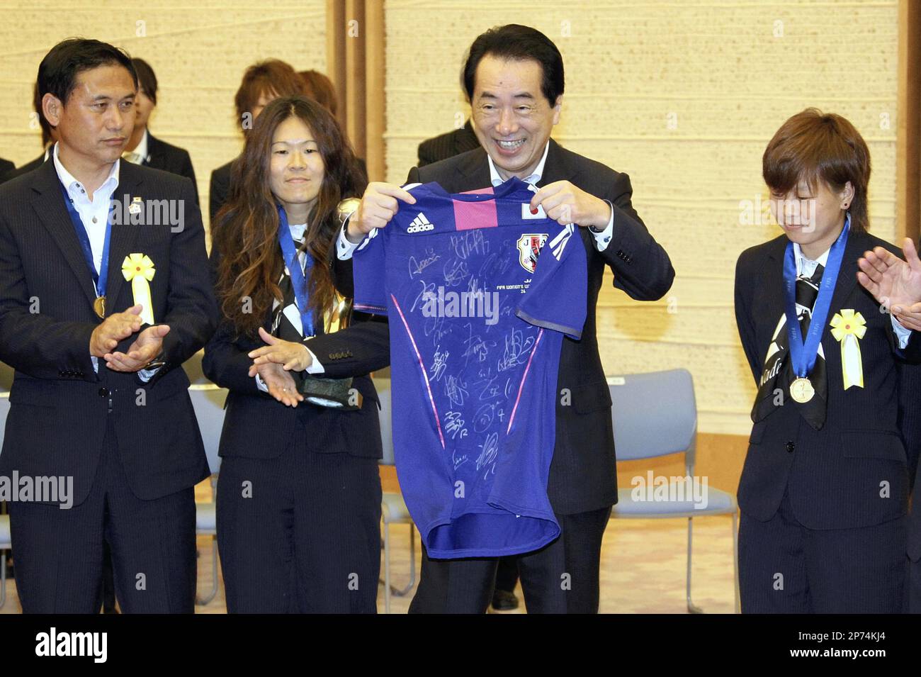 Prime Minister Naoto Kan (2nd from right) shows off a national