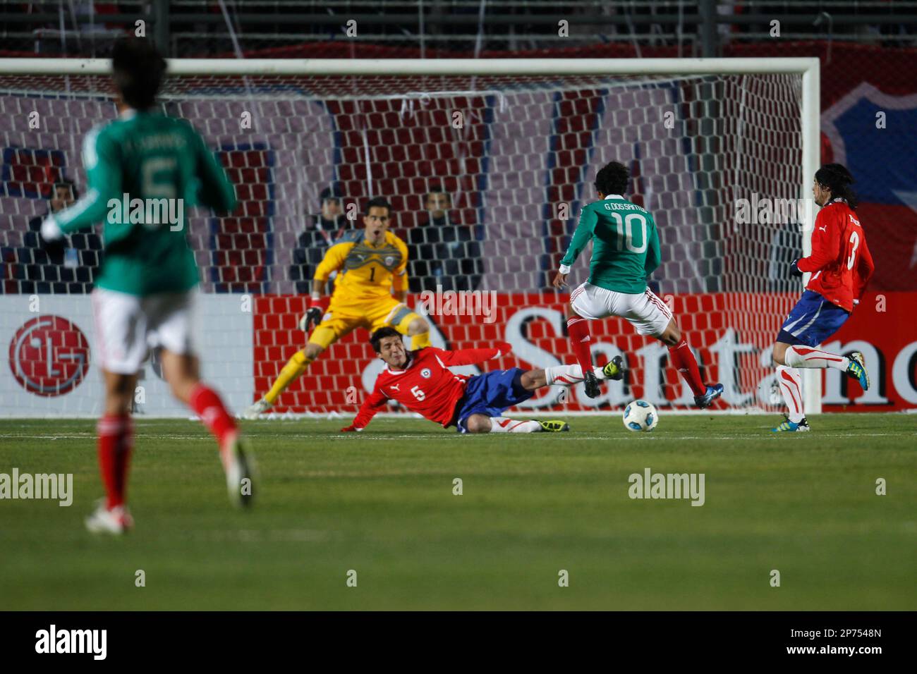 Mexico's Giovani Dos Santos, second from right, tries to score against Chile's goalkeeper Claudio Bravo, center, as teammate Pablo Contreras joins in the defense during a Copa America Group C soccer match in San Juan, Argentina, Monday, July 4, 2011. (AP Photo/Roberto Candia) Stock Photo