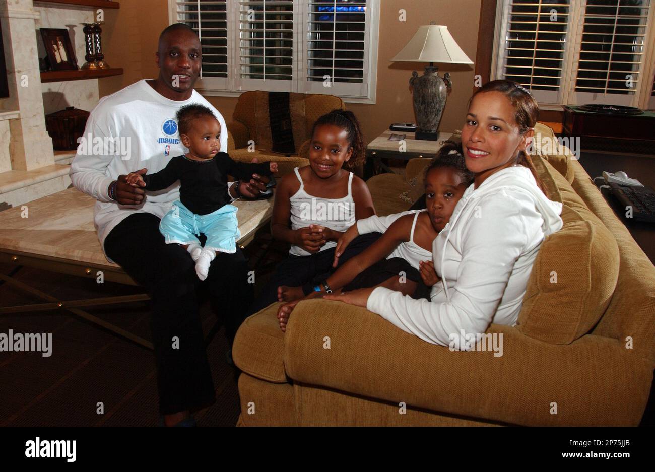 The Orlando Magic's Dee Brown, left, sits with his wife, Tammy, right, and  daughters Alanni, second from left, Alexis, center, and Alyssa, second from  right, in the entertainment room of their home