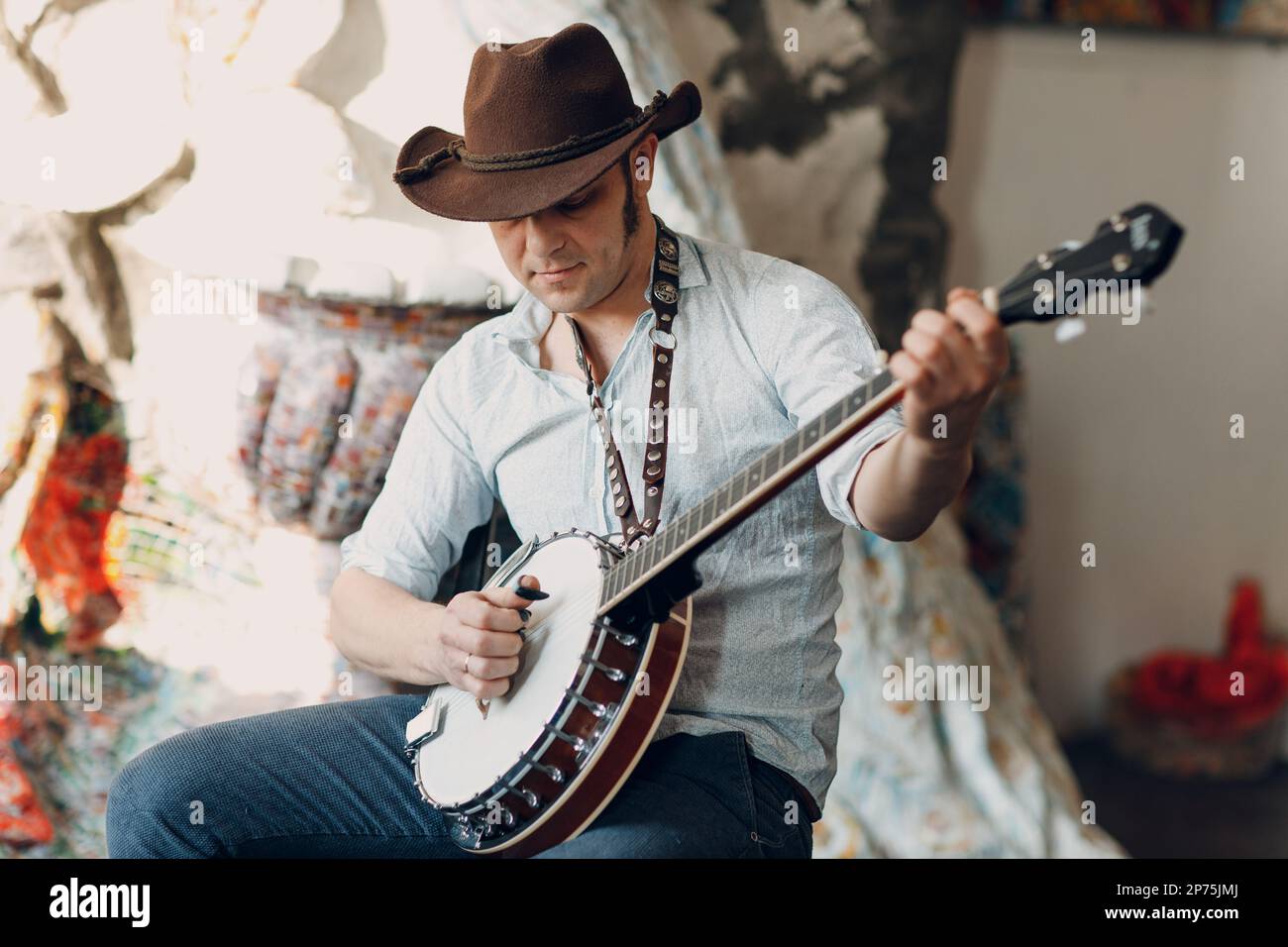 Male musician playing banjo sitting chair indoor Stock Photo - Alamy