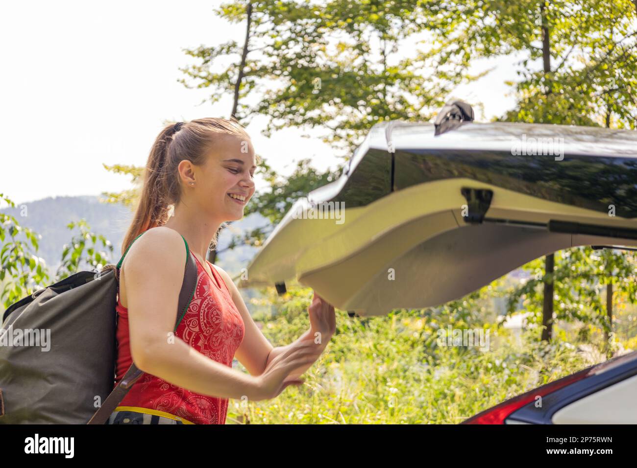 Young woman leaving car with climbing equipment Stock Photo Alamy